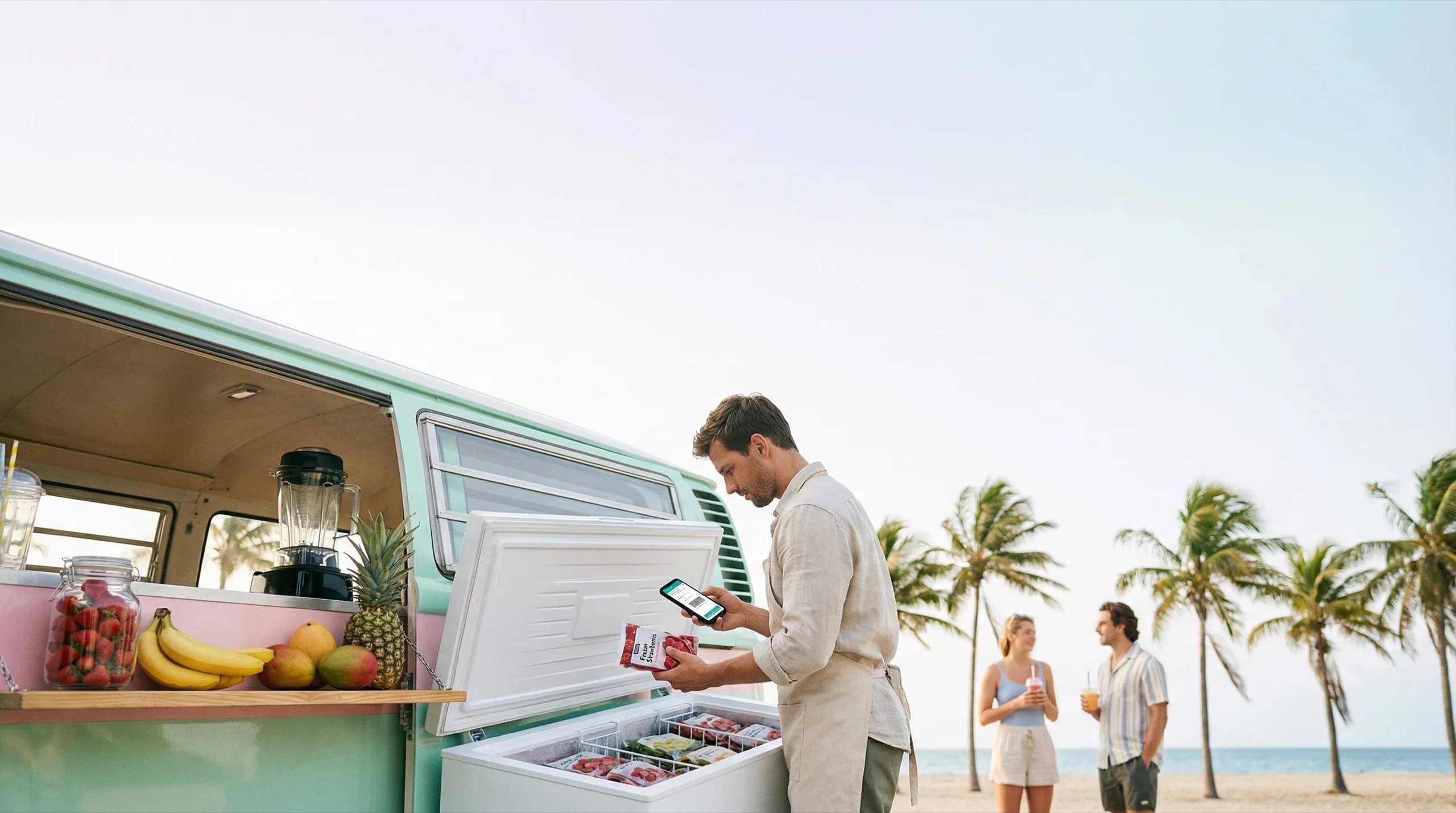 Man using handheld POS at a beach food van