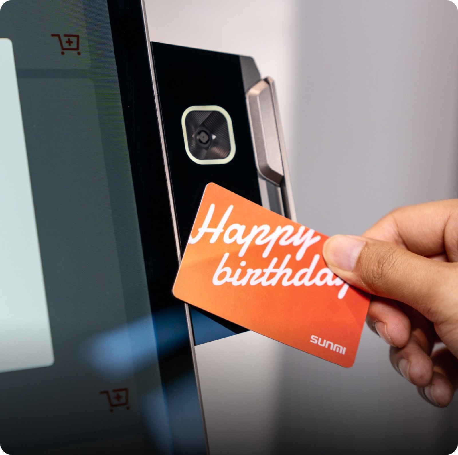 A membership card held to the reader module on the side of a kiosk