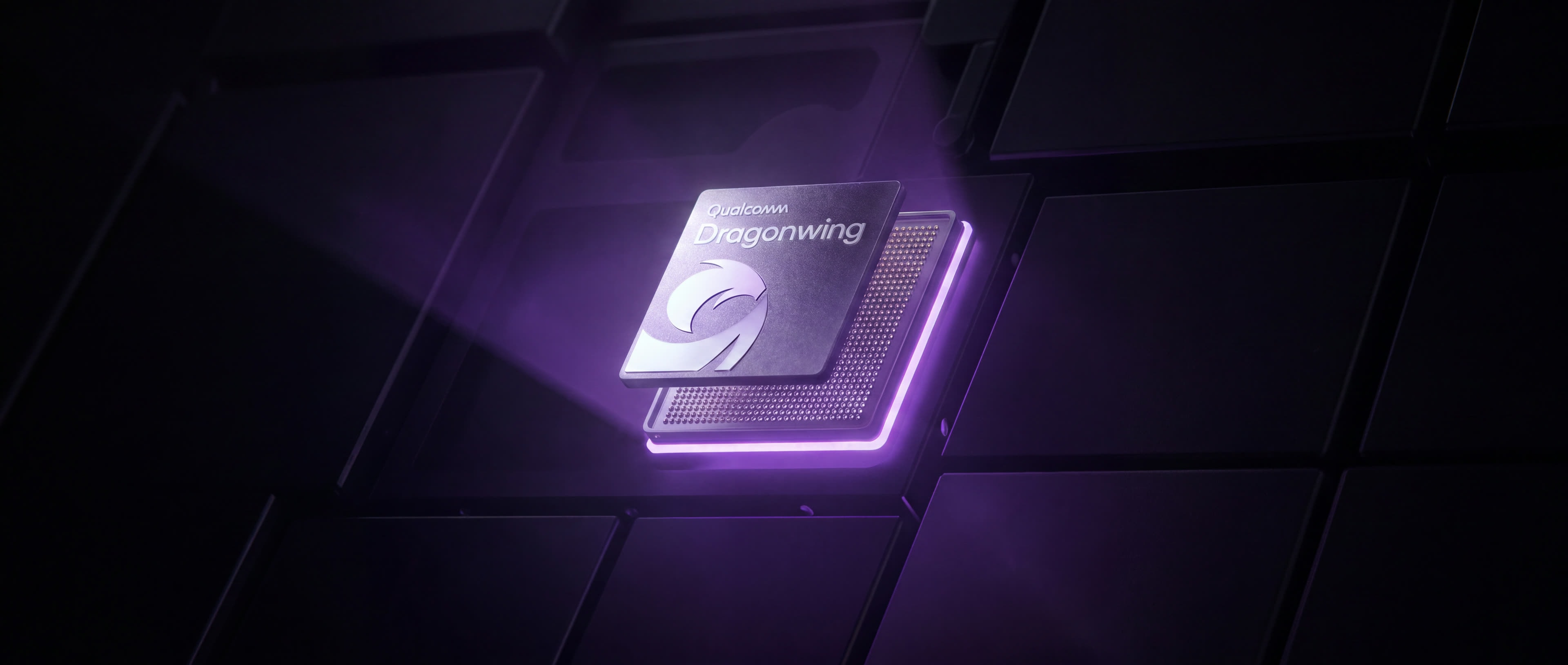 A processor lit from beneath on a dark board, its top face carrying the Qualcomm Dragonwing mark