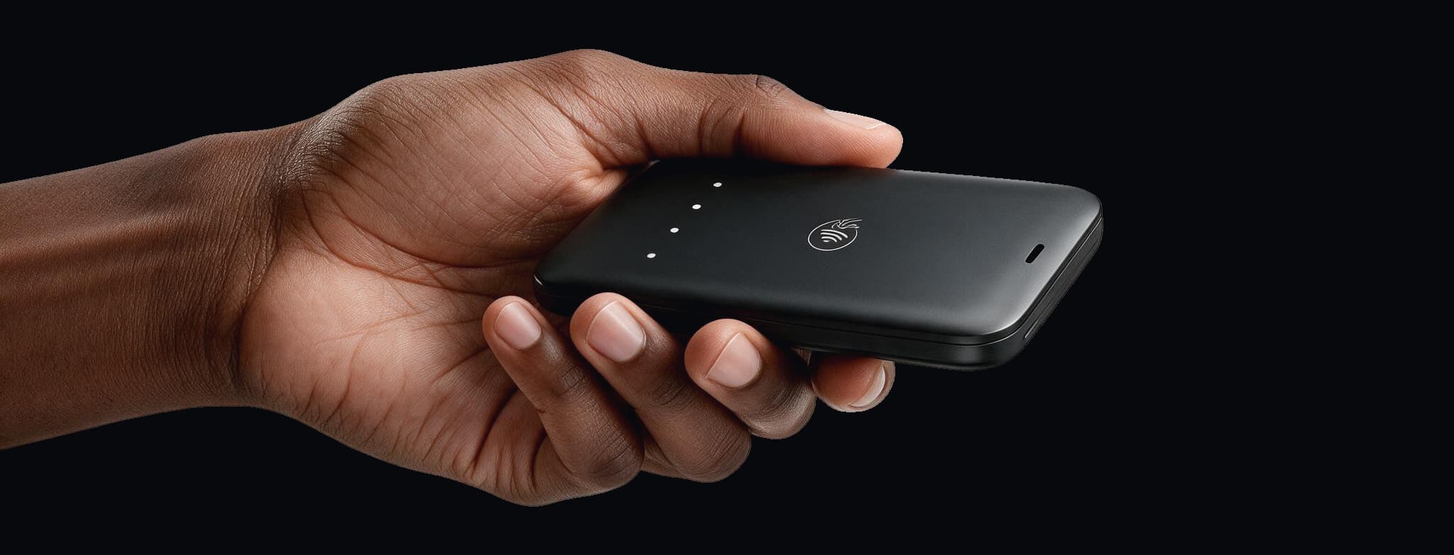 A hand reaching in from the left holding the Final Move reader flat on its palm, on a near-black ground