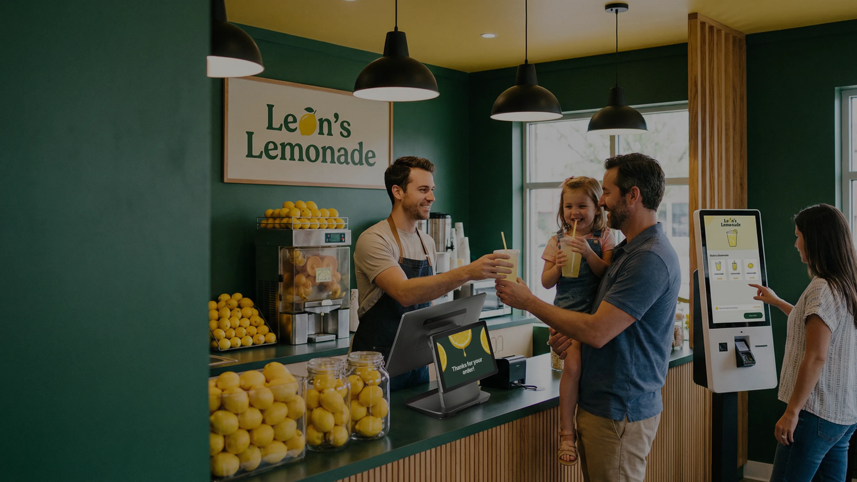 Cafetería Leon's Lemonade con un quiosco de autoservicio y una familia en el mostrador